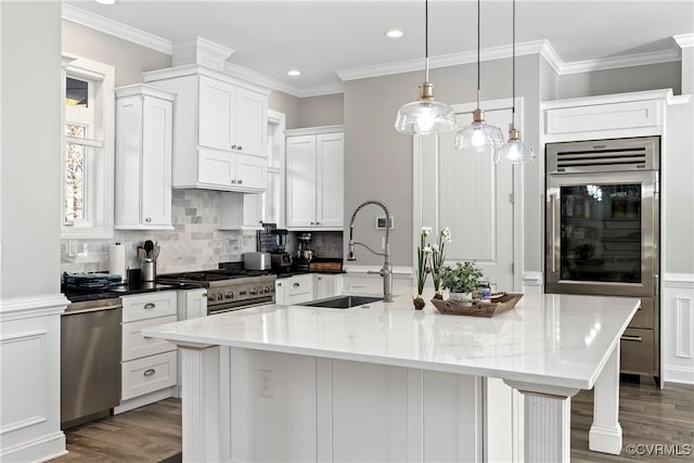 kitchen with light stone counters, sink, an island with sink, and appliances with stainless steel finishes