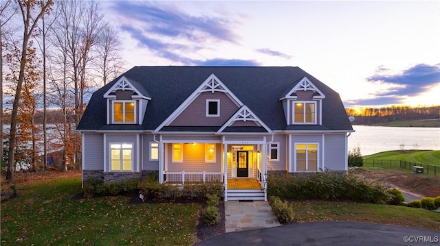 craftsman-style house with covered porch and a water view