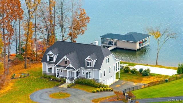 view of front facade featuring a water view, a garage, and a front lawn