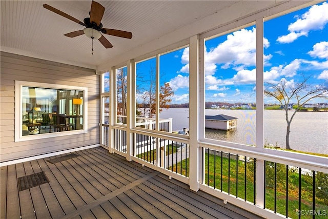 unfurnished sunroom with ceiling fan and a water view