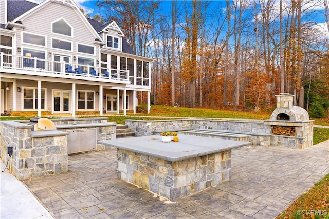 view of patio / terrace with an outdoor kitchen and an outdoor stone fireplace