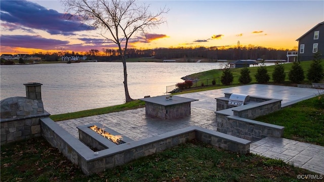 exterior space with area for grilling, a water view, and an outdoor fire pit