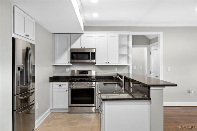 kitchen featuring white cabinetry, kitchen peninsula, and stainless steel appliances