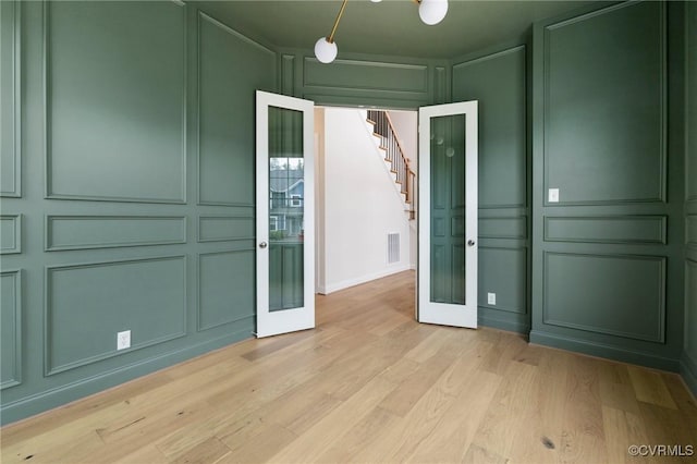 15812 W Millington Dr, Midlothian, VA 23112 - empty room featuring a decorative wall, french doors, light wood-type flooring, and stairs