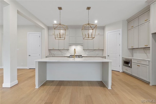 15812 W Millington Dr, Midlothian, VA 23112 - kitchen with recessed lighting, decorative backsplash, light countertops, an island with sink, and light wood-style floors
