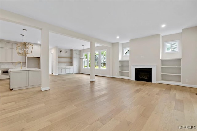 15812 W Millington Dr, Midlothian, VA 23112 - unfurnished living room with light wood-style floors, a fireplace, recessed lighting, built in shelves, and baseboards
