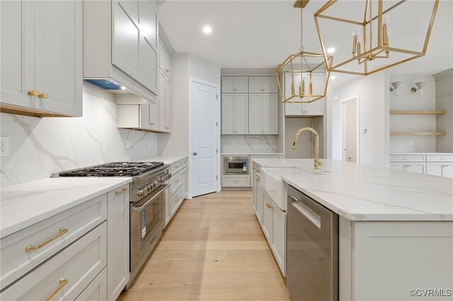 15812 W Millington Dr, Midlothian, VA 23112 - kitchen featuring stainless steel appliances, a sink, a chandelier, light wood finished floors, and a kitchen island with sink