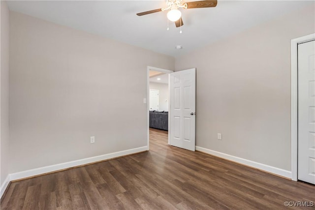 unfurnished bedroom with ceiling fan and dark wood-type flooring