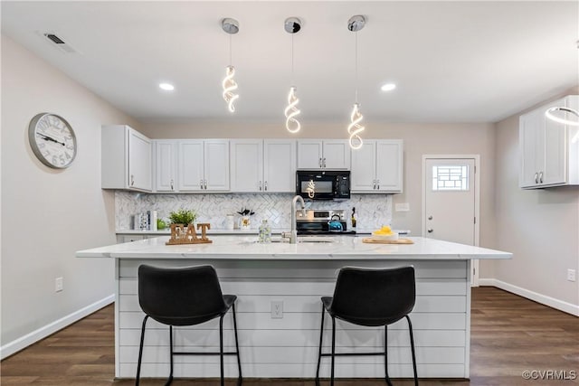 kitchen featuring white cabinets, a center island with sink, and stainless steel electric stove