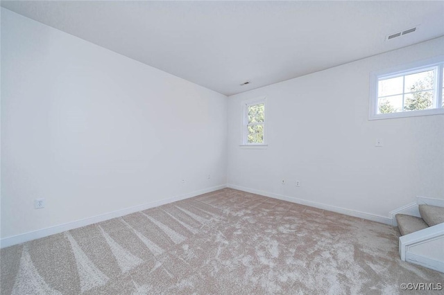 unfurnished room with plenty of natural light and light colored carpet