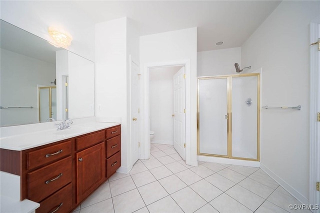 bathroom with tile patterned flooring, vanity, toilet, and walk in shower