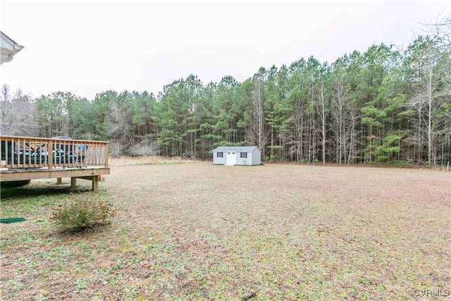 view of yard featuring a storage unit and a wooden deck