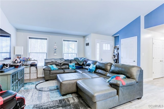 living room featuring light wood-type flooring and lofted ceiling