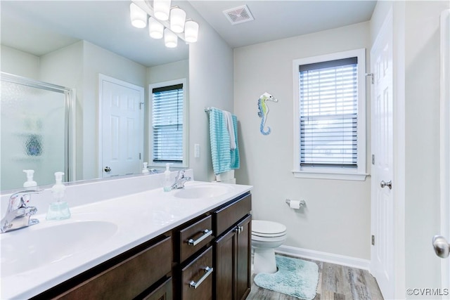 bathroom featuring hardwood / wood-style floors, vanity, toilet, and an enclosed shower