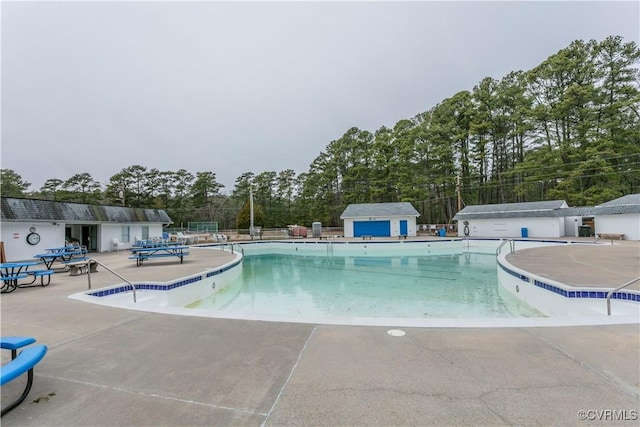 view of pool featuring an outbuilding and a patio