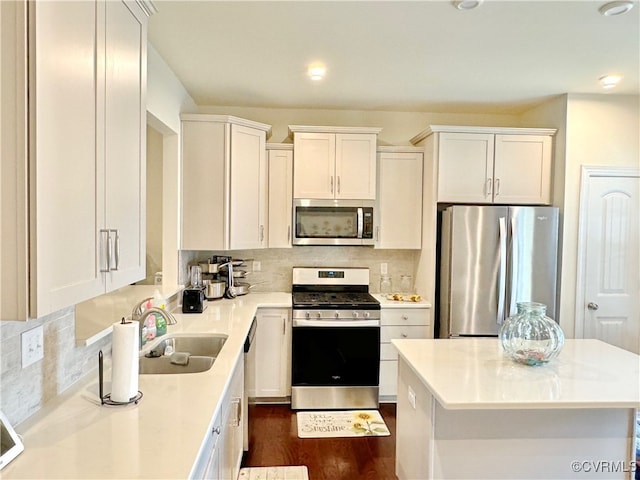 kitchen featuring stainless steel appliances, white cabinetry, and sink