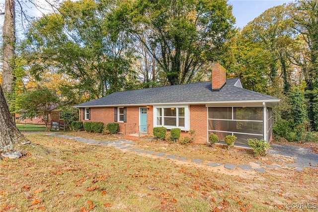 ranch-style home featuring a front yard and a sunroom