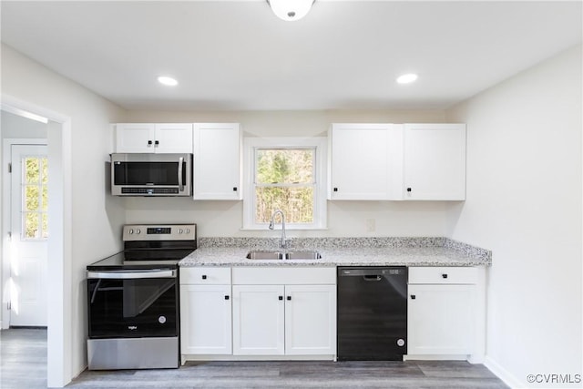 kitchen featuring white cabinets, hardwood / wood-style floors, stainless steel appliances, and sink