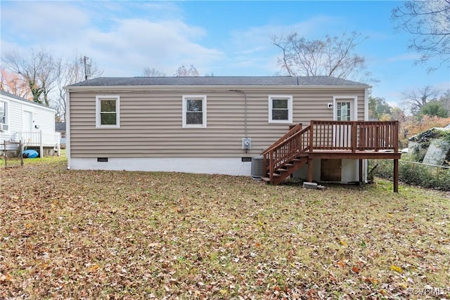 back of property with a lawn and a deck