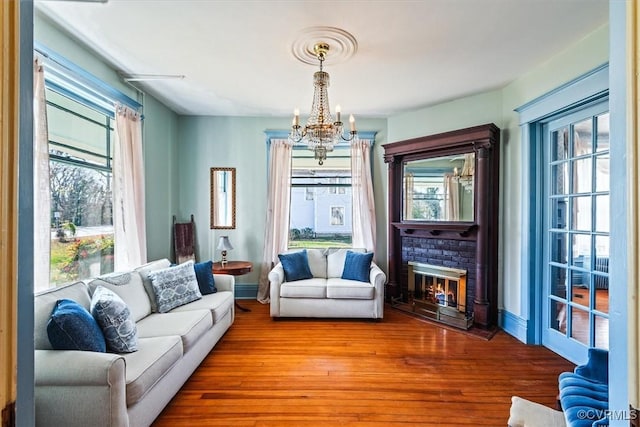 living area featuring a chandelier, hardwood / wood-style floors, and a fireplace