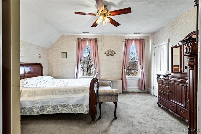 carpeted bedroom with radiator, vaulted ceiling, and ceiling fan