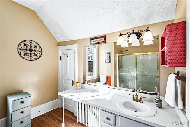 bathroom featuring vanity, lofted ceiling, a textured ceiling, walk in shower, and wood-type flooring