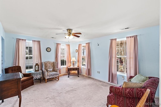 sitting room with ceiling fan and light colored carpet