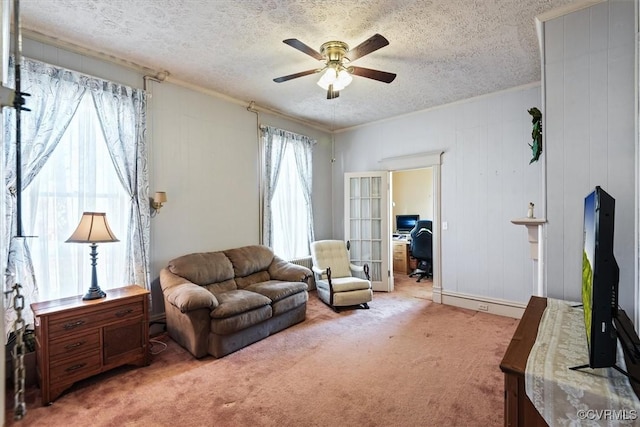 living area featuring carpet flooring, a textured ceiling, and ceiling fan