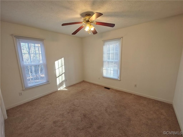 carpeted empty room featuring a textured ceiling and ceiling fan