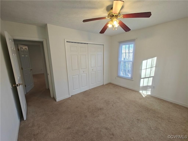 unfurnished bedroom with light colored carpet, a closet, and ceiling fan