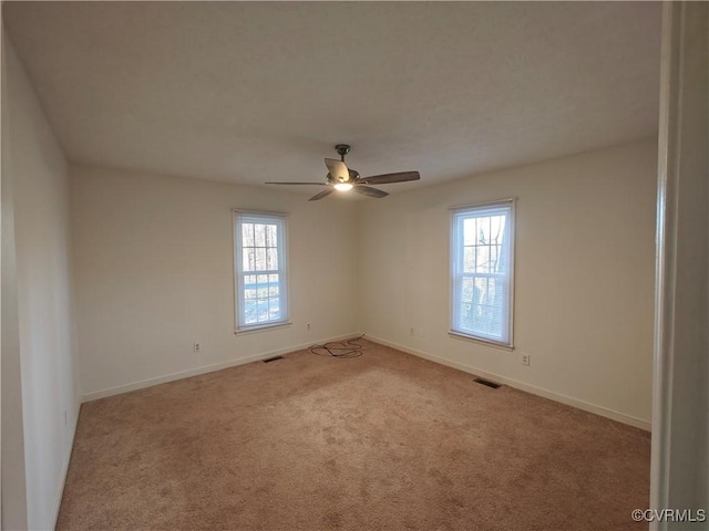 unfurnished room with ceiling fan and light carpet