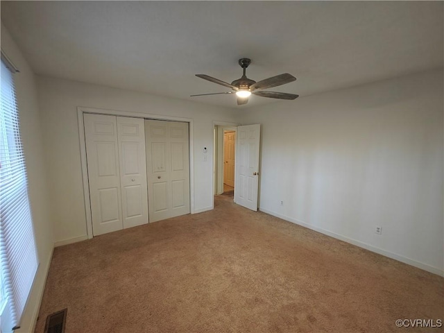 unfurnished bedroom with light colored carpet, ceiling fan, and a closet