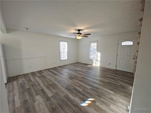 interior space featuring dark wood-type flooring, a textured ceiling, and ceiling fan