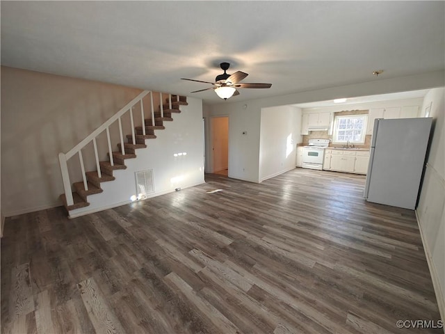 unfurnished living room with sink, dark wood-type flooring, and ceiling fan