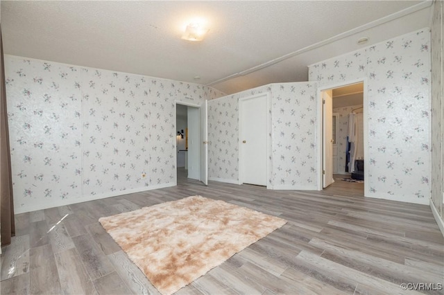 unfurnished room featuring a textured ceiling and hardwood / wood-style flooring