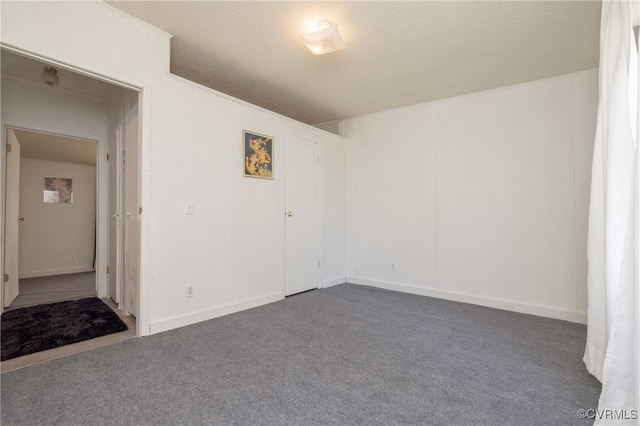 unfurnished room featuring carpet and a textured ceiling