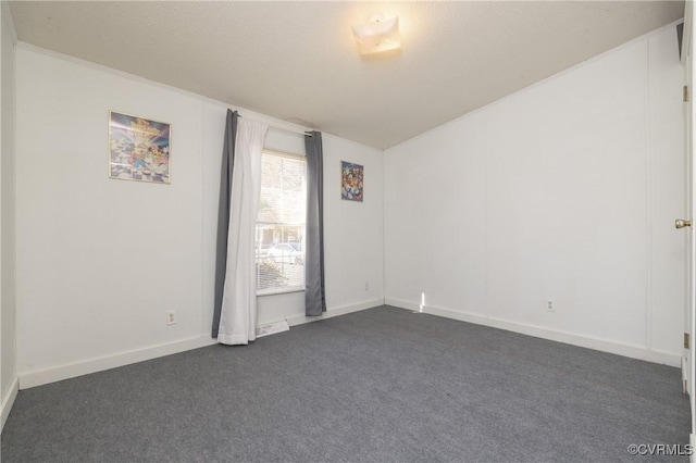 spare room with dark colored carpet