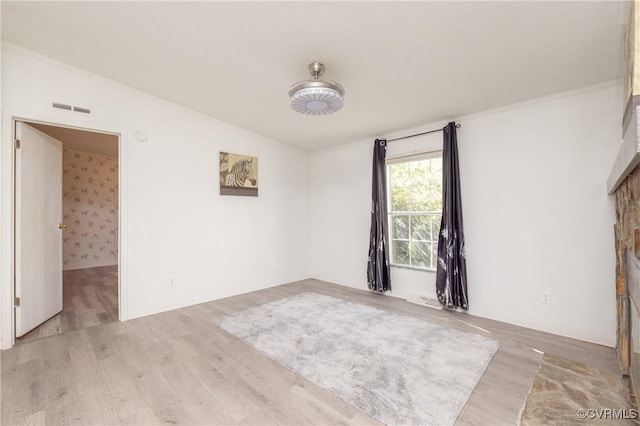 unfurnished room with light hardwood / wood-style floors and lofted ceiling