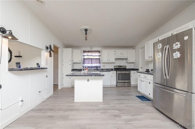 kitchen featuring white cabinets, a center island, stainless steel appliances, and a textured ceiling