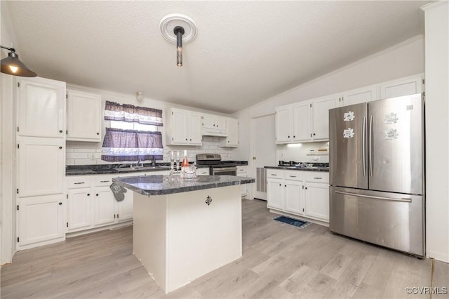 kitchen with white cabinetry, a center island, lofted ceiling, and appliances with stainless steel finishes