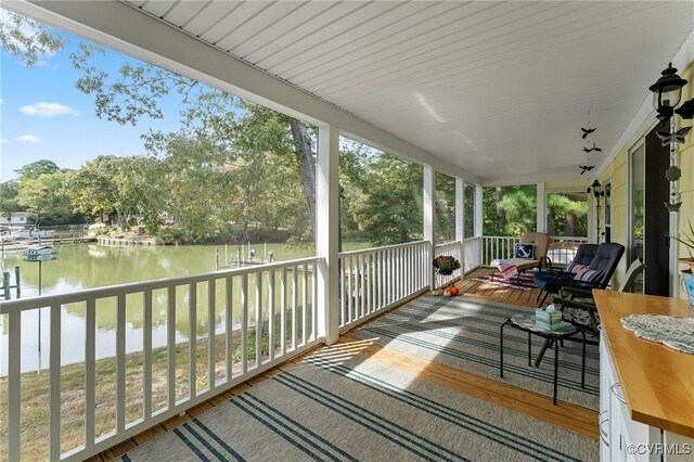 sunroom / solarium featuring a wealth of natural light and a water view