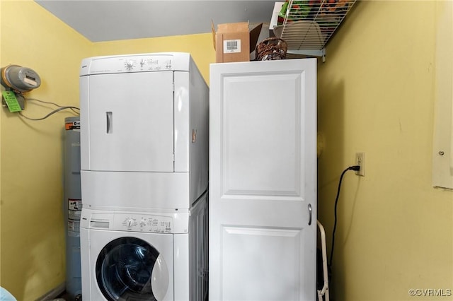 clothes washing area with cabinets and stacked washer / drying machine