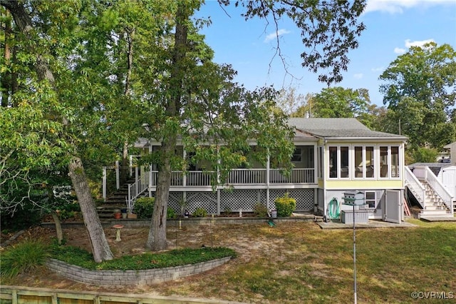 back of property with a yard and a sunroom