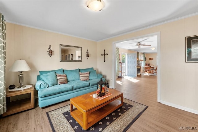 living room with hardwood / wood-style floors, ceiling fan, and ornamental molding