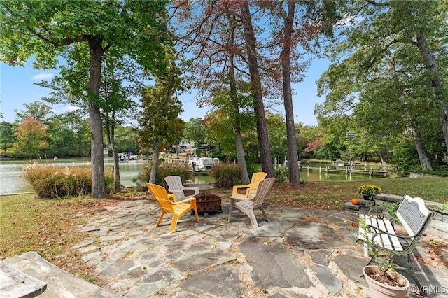 view of patio with a water view and a fire pit