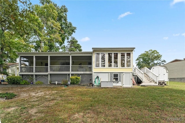 rear view of house featuring a lawn, a sunroom, and a storage unit