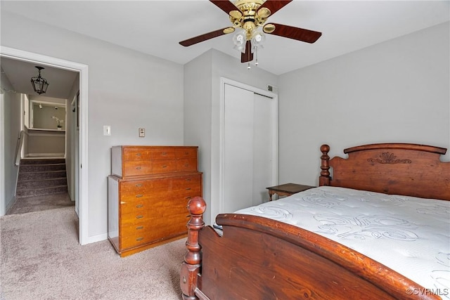 carpeted bedroom with ceiling fan and a closet