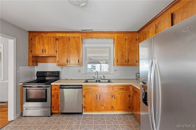 kitchen with baseboard heating, sink, light tile patterned floors, and appliances with stainless steel finishes