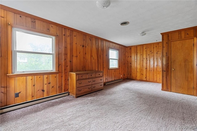 carpeted empty room with crown molding and a baseboard heating unit