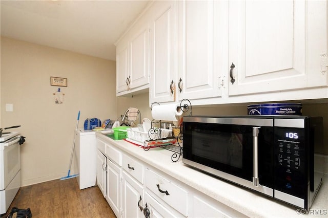 kitchen featuring washer / clothes dryer, white cabinets, dark hardwood / wood-style floors, and white stove